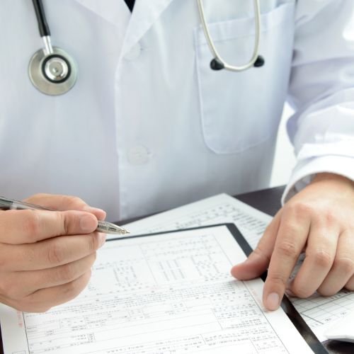 medico escribiendo en documentos en pagina Certificados Médicos Alt Gironella Barcelona